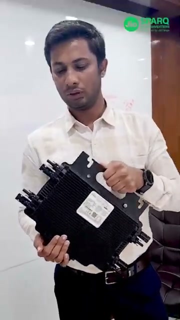 A Quad microinverter held in two hands at the start of the Quad 2000 installation film
